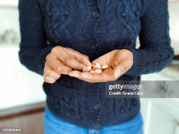 woman snacks on mixed nuts - handful stock pictures, royalty-free photos & images