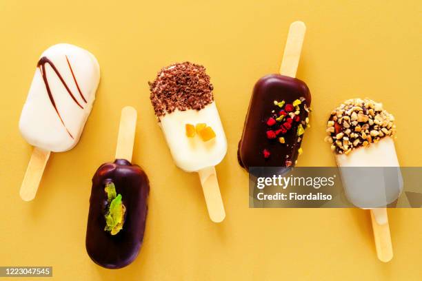 ice cream on a stick on a yellow background. - chocolate cake above fotografías e imágenes de stock