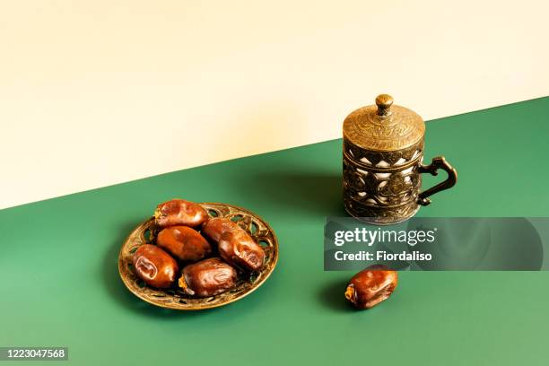 turkish metal coffee cup with lid and saucer with dates - eid al fitr celebration to mark the end of ramadan stockfoto's en -beelden