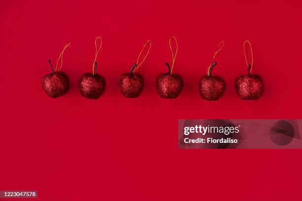 toy artificial christmas apples on a red background - december 6 stock pictures, royalty-free photos & images