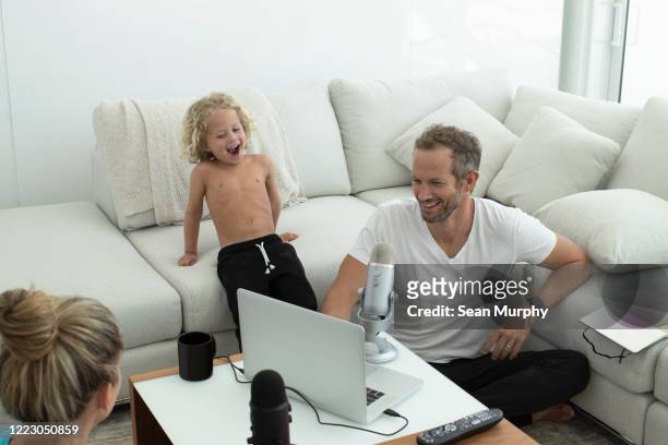 Dad and son laughing doing a podcast together.