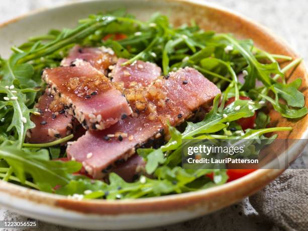 salade de thon ahi et roquette en croûte de graines de sésame avec une vinaigrette au gingembre à l’ail et au soja - vinaigrette dressing photos et images de collection