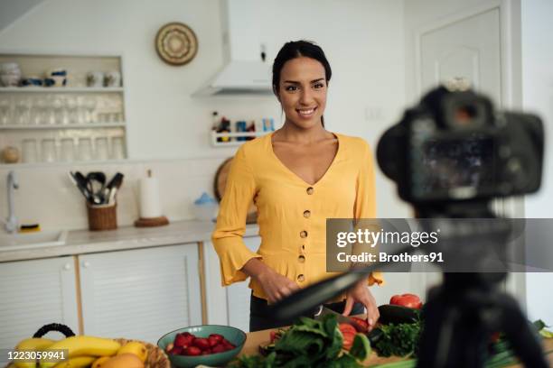 attraktive junge frau, social-media-influencer-aufnahme für ihren youtube-kanal - cooking on camera stock-fotos und bilder