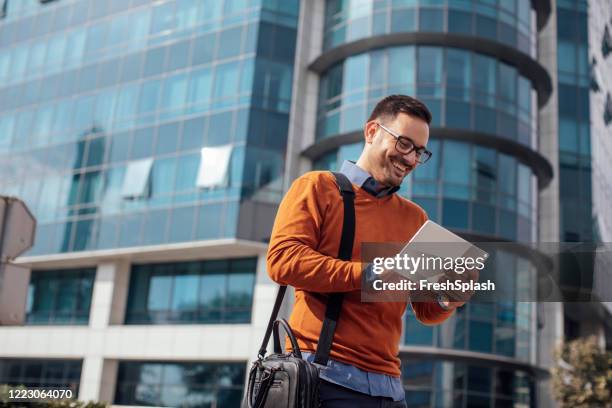 succesvolle moderne jonge zakenman die een digitale tablet op de straat gebruikt - young businessman digital tablet stockfoto's en -beelden