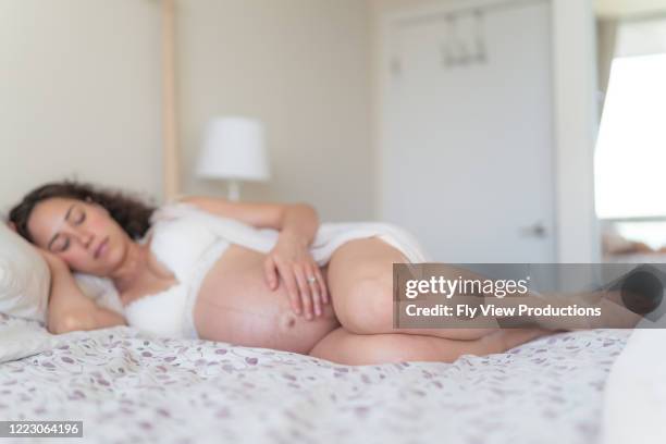 pregnant woman laying in bed - back pain bed stock pictures, royalty-free photos & images