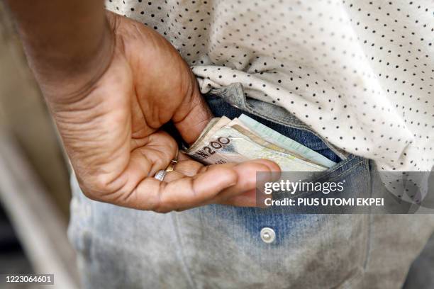 Man keeps his money in his back pocket in a Lagos om April 15, 2008. In Nigeria, where officials are keen to clean up a reputation for massive...