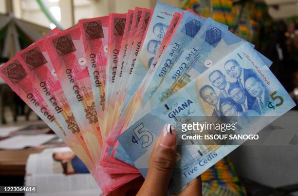 Woman holds 03 July 2007 in Accra a wad new currency, the new cedi, that Ghana put in circulation that day, although the old money will still be...