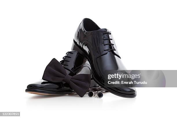 cufflinks, shoe and tuxedo bow tie on the white ba - black tux with white tie foto e immagini stock