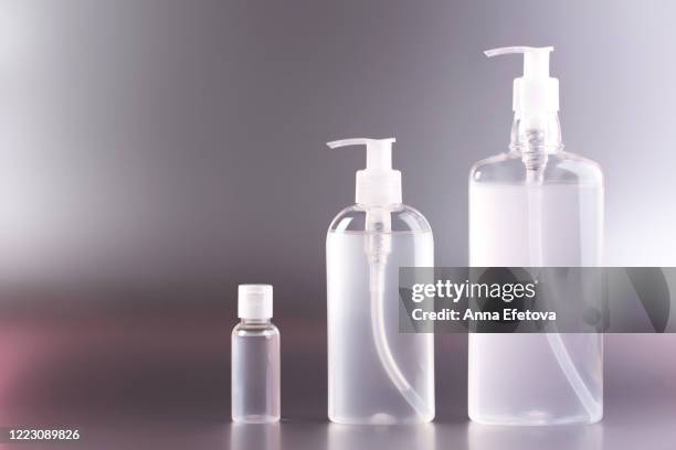 group of transparent bottles with antibacterial gel inside. - tape dispenser stock pictures, royalty-free photos & images