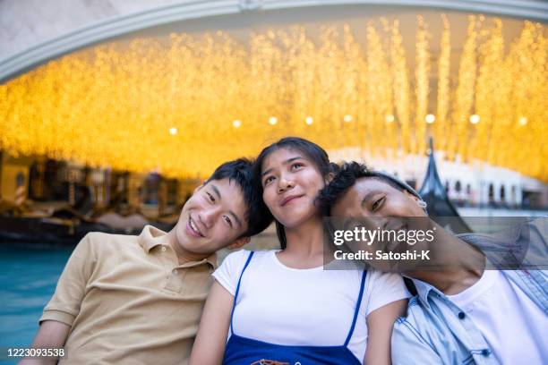 young friends leaning each other on boat - daily life in manila imagens e fotografias de stock