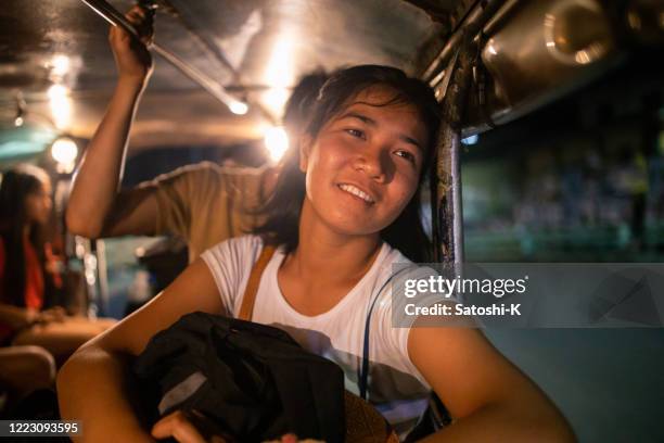 young philipino woman riding jeepney in manila - philippines jeepney stock pictures, royalty-free photos & images