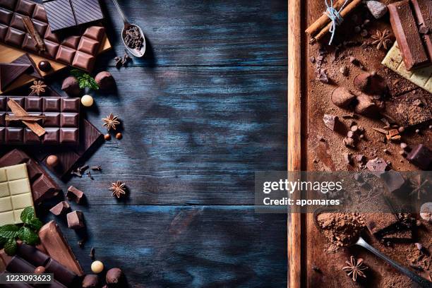 lågmäld bild av en mängd olika choklad och bombones med torkad frukt. gammaldags stil på ett blått rustikt bord med kopieringsutrymme - bombones chocolate bildbanksfoton och bilder