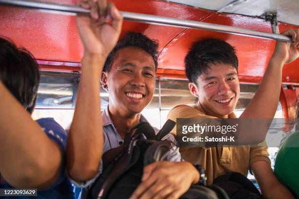 amici asiatici in sella a jeepney nelle filippine - manila philippines foto e immagini stock