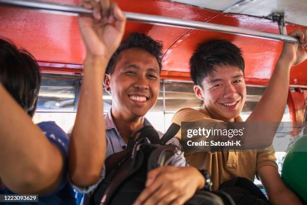 aziatische vrienden die jeepney in filippijnen berijden - quezon stad stockfoto's en -beelden