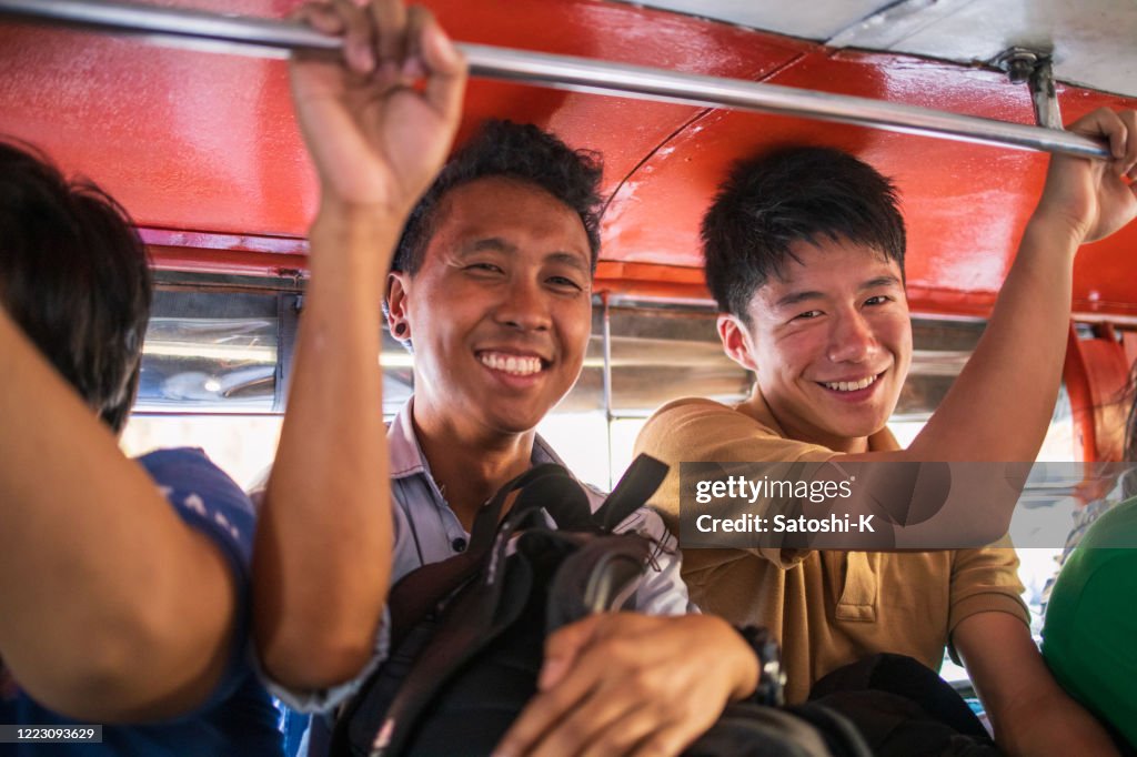 Asiatiska vänner ridning jeepney i Filippinerna