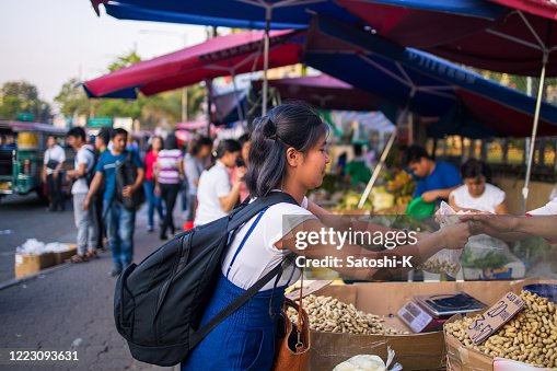 Young Asian woman buying food at street food stall Young Asian woman buying food at street food stall