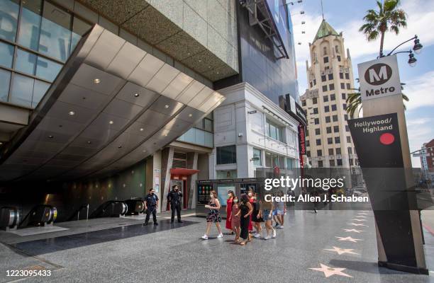 Officers E. Rosales, left, and D. Castro, patrol the Metro Red Line Hollywood/Highland Metro Station as tourists pass by Thursday, June 25, 2020 in...