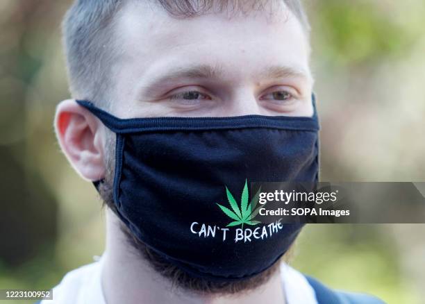 Protester wears a face mask with hemp image and saying Can't breathe during a rally. The participants demand Ukrainian officials reform of state drug...