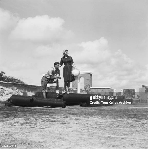 young couple standing on cannon, smiling - 1963 stock pictures, royalty-free photos & images