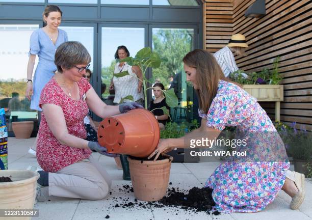 Catherine, Duchess of Cambridge helps to pot plants and herbs during a visit to The Nook in Framlingham Earl, Norfolk, which is one of the three East...