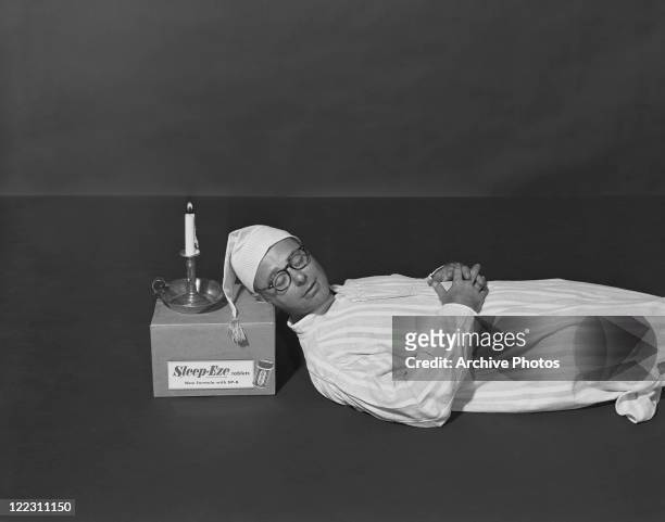 Man resting head on box with candle