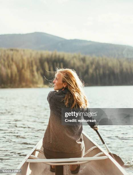 beautiful healthy active woman canoeing on a lake at sunset - bozeman stock pictures, royalty-free photos & images