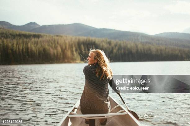 beautiful healthy active woman canoeing on a lake at sunset - bozeman stock pictures, royalty-free photos & images