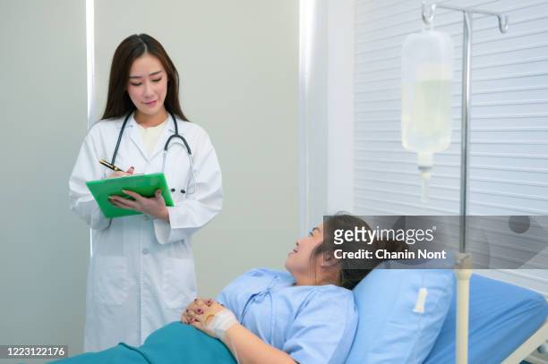 doctors encourage patients to sleep on the bed - iv drip womans hand fotografías e imágenes de stock