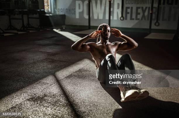 zweterige zwarte atleet die sit-ups in een gymnastiek doet. - sit ups stockfoto's en -beelden