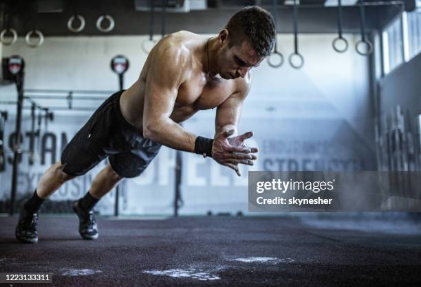 muscular build athlete having gym training in a gym. - crossfit training stock pictures, royalty-free photos & images