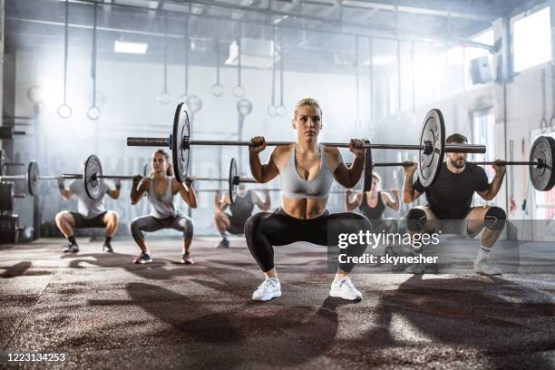 gran grupo de atletas que tienen entrenamiento de pesas en un gimnasio. - crossfit training fotografías e imágenes de stock