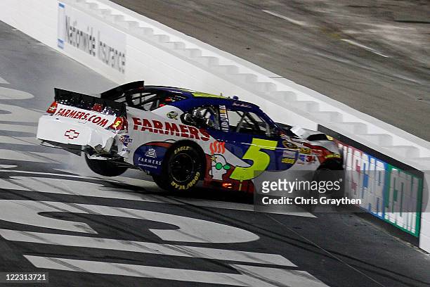Mark Martin, driver of the Farmers Insurance/GoDaddy.com Chevrolet, hits the wall during the NASCAR Sprint Cup Series Irwin Tools Night Race at...