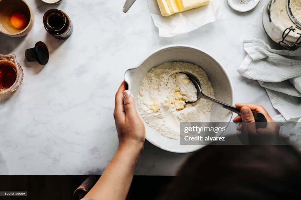 Woman preparing fruit pie dough with flour and butter