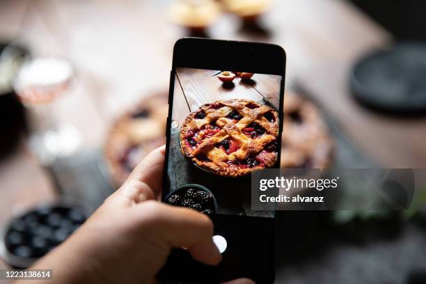het fotograferen van een roosterfruittaart met een slimme telefoon - pie stockfoto's en -beelden