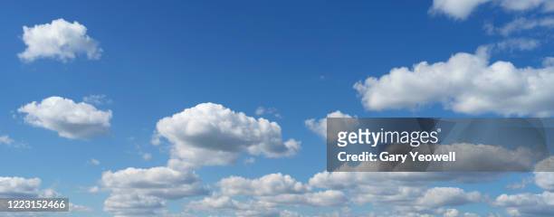 fluffy clouds against blue sky - fonds de nuage photos et images de collection