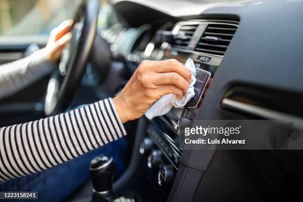 female hands cleaning and disinfecting her car interior - clean car stock pictures, royalty-free photos & images