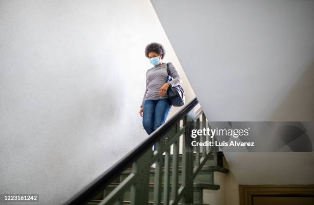 woman with face mask leaving home during covid-19 pandemic - covid commuter stock pictures, royalty-free photos & images