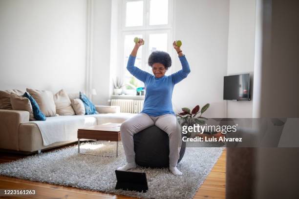 woman is doing online workout during covid-19 lockdown - sport tablet stock pictures, royalty-free photos & images