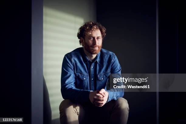 portrait of a relaxed casual businessman sitting down - licht schatten stock-fotos und bilder