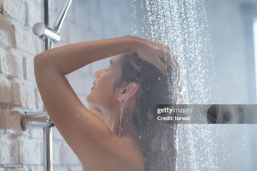 Aziatische vrouw Genieten van de douche Ze is het wassen van haar haar.