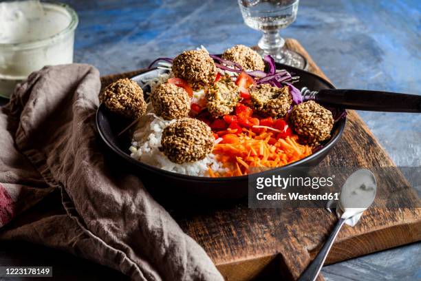 bowl of ready-to-eat salad with white and red cabbage, carrots, rice and spinach falafel - falafel stock-fotos und bilder