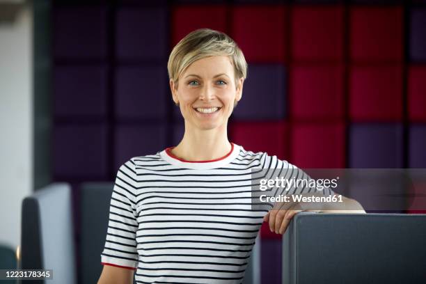 portrait of a smiling woman at a purple wall - monochrome clothing stock-fotos und bilder