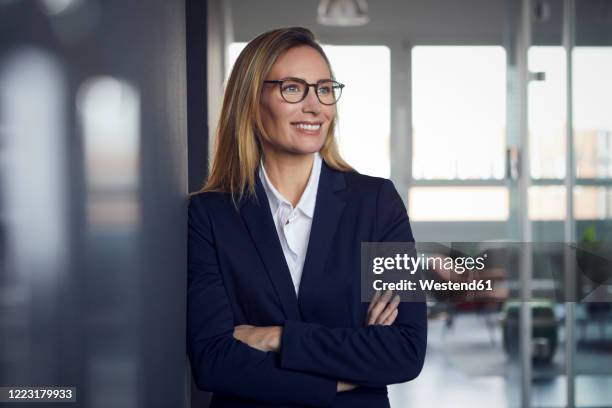 portrait of smiling businesswoman in office - white blazer stock-fotos und bilder