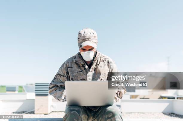 soldier with face mask on emergency operation, using laptop - ominous computer stock pictures, royalty-free photos & images
