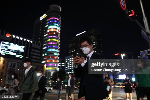 People walk along the street in face masks on May 06, 2020 in Seoul, South Korea. South Korea returned largely to normal as citizens return to their...