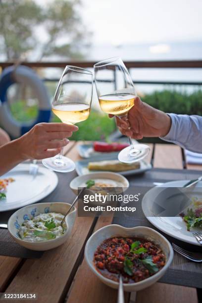 romantic dinner tables with champaigne near the sea. - waterfront dining stock pictures, royalty-free photos & images