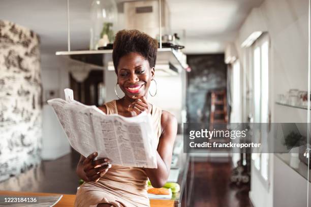 happiness woman in the kitchen reading a newspaper - large envelope stock pictures, royalty-free photos & images