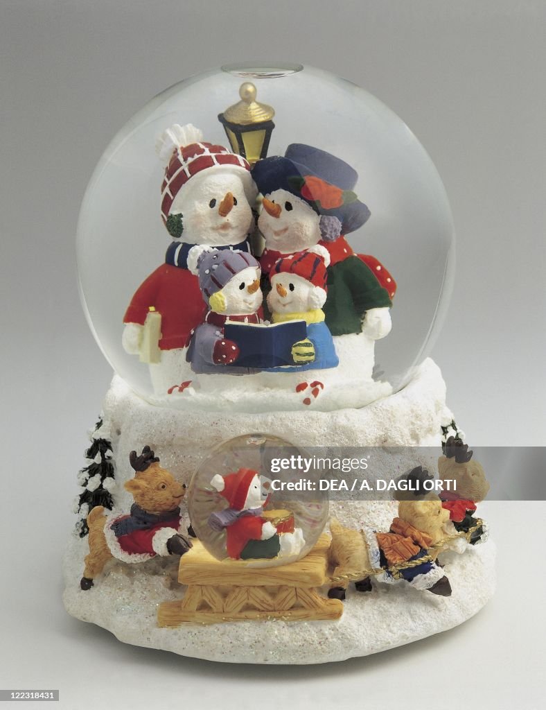 Close-up of figurines of a snowman family in a snow globe