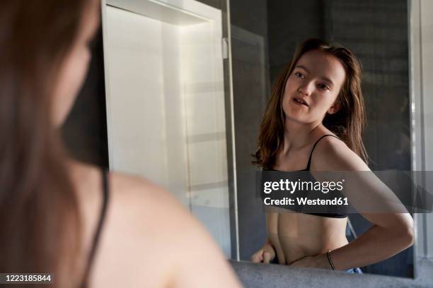 mirror image of girl watching herself in bathroom - kids in undies stockfoto's en -beelden