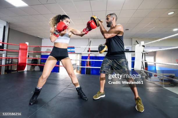 female boxer sparring with her coach in gym - boxing womens foto e immagini stock